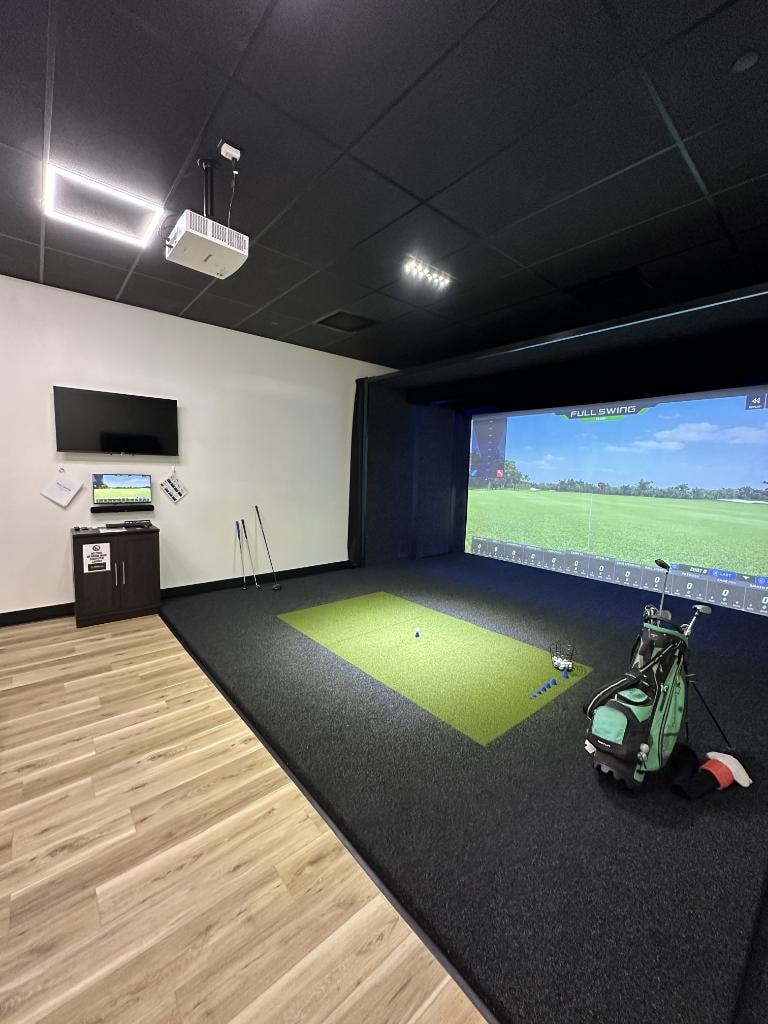 Indoor golf simulator room with a high-tech screen setup